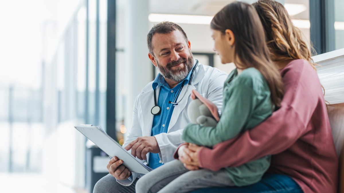 Doctor explaining test results to girl patient at examination in a modern medical clinic with her parent